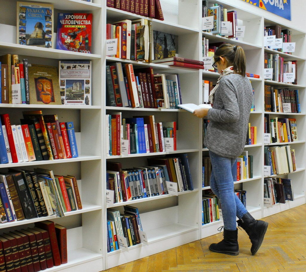Дівчина вибирає книгу в книгарні